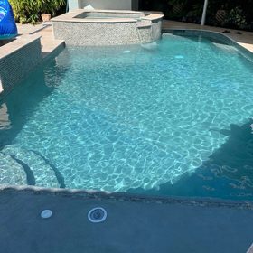 Pool with sun shelf and raised spa finished in Diamond Brite French Gray.
