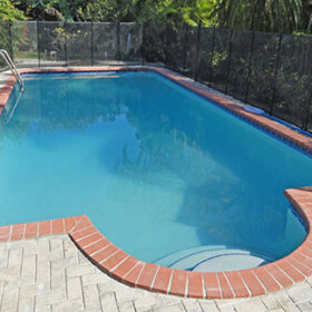 Backyard with a fenced in pool. Pool is finished in Diamond Brite Super Blue.